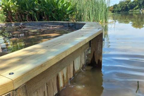 Treated wood bulkhead framing a curved waterside enclosure