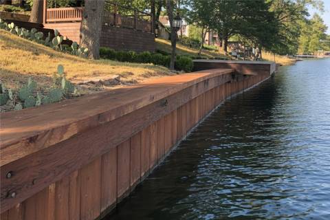 Treated wood bulkhead with wide cap along gentle lake slope